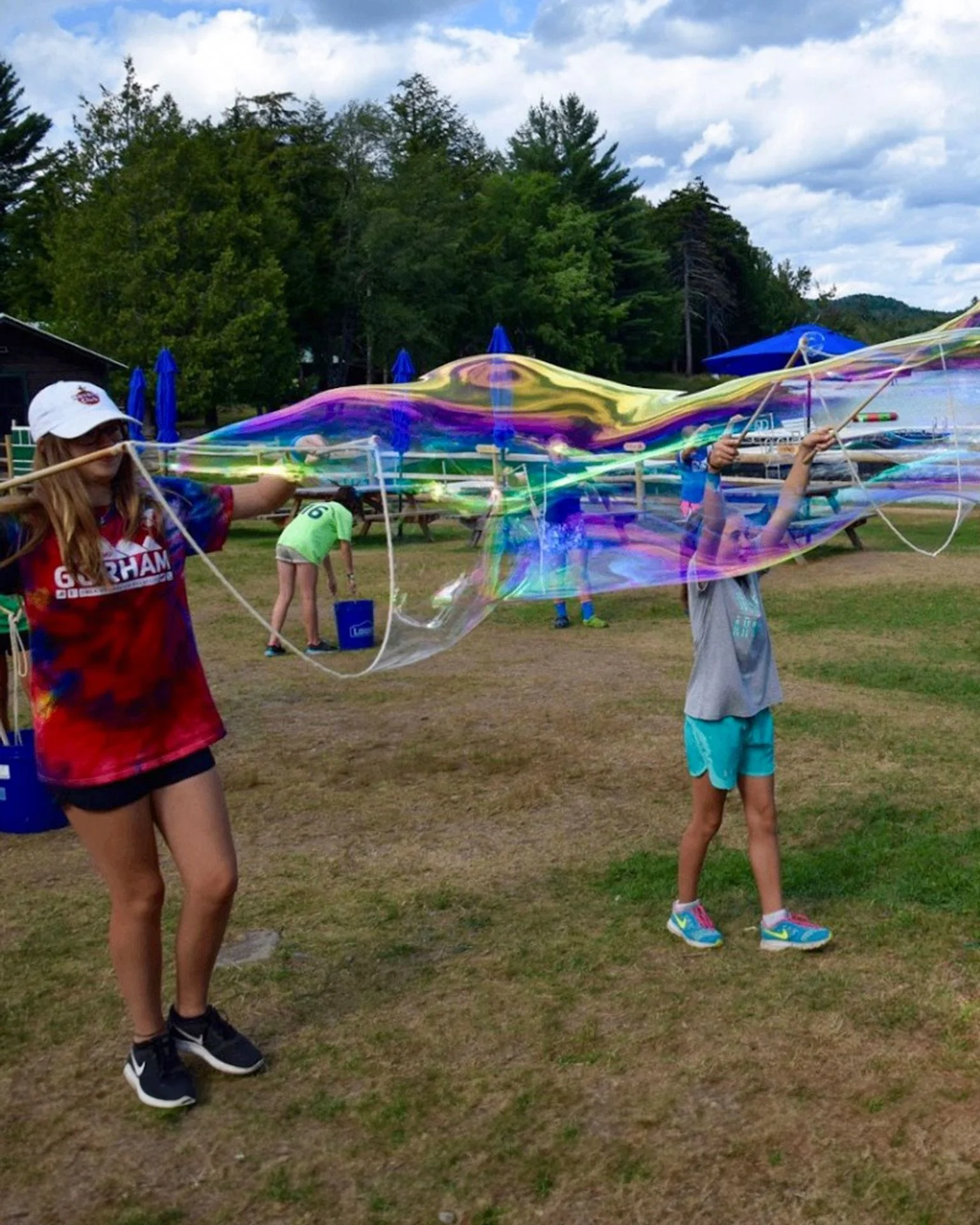 Children at summer camp making giant colorful bubbles together with the BubbleStix Camp Pack