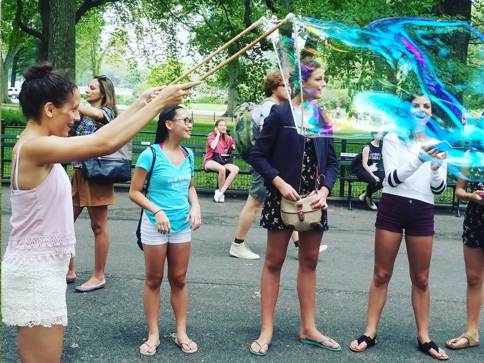 BubbleStix review — Elena R., Austin, Texas Teens making giant iridescent bubbles together in the park with BubbleStix